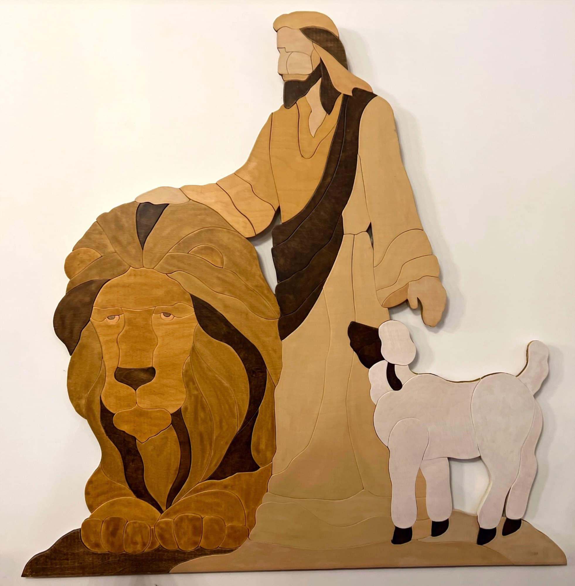 A hand-cut wood inlay of Christ with a lion and a lamb, made for the church