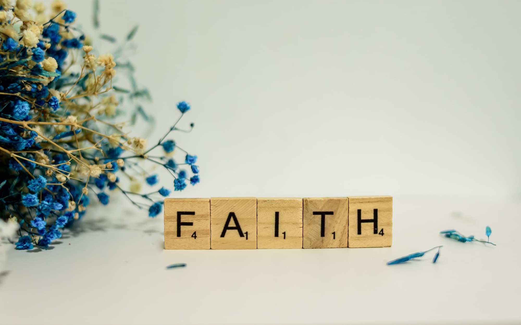 The word FAITH spelled out in wooden letter tiles