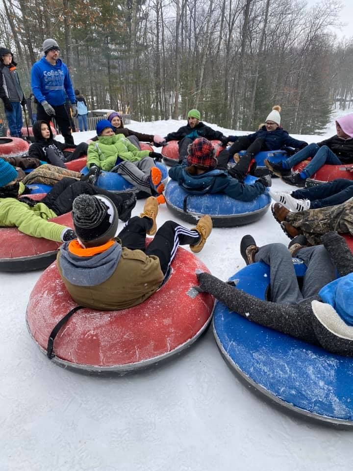 Blissfield Baptist teens tubing in the snow at Camp CoBeAc